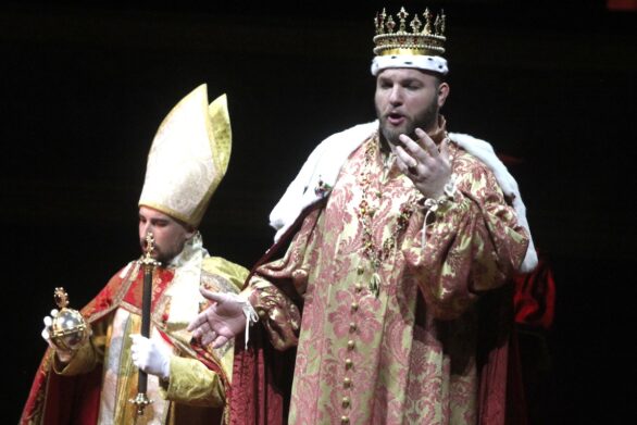 Primo piano di attori sul palco immersi nei loro personaggi nell'opera "Ernani"
