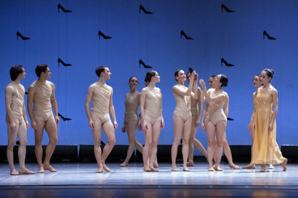 delle ballerine si passano la "scarpetta" di Cenerentola, mentre intorno a loro altri personaggi le osservano curiosi