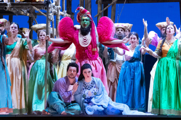 attori in maschera sul palco immersi nei loro personaggi durante l'opera "Les pêcheurs de perles". Indossano dei vestiti colorati
