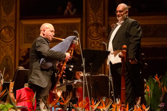 primo piano del direttore d'orchestra e dello zampognaro all'interno del teatro durante il concerto di Capodanno delle formazioni giovanili