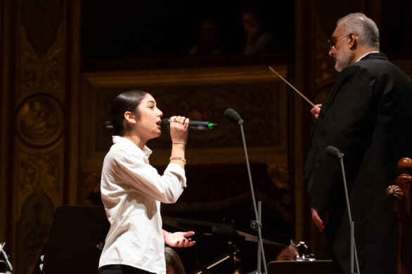 primo piano di una cantante e del direttore d'orchestra all'interno del teatro durante il concerto di Capodanno delle formazioni giovanili