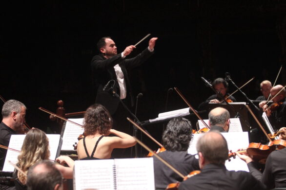 primo piano del direttore d'orchestra e dell'orchestra all'interno del teatro durante il concerto di San Silvestro
