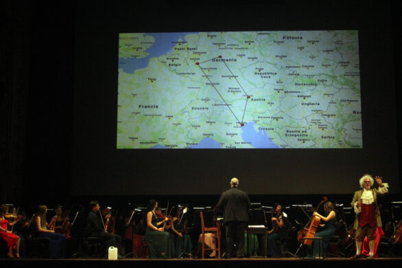 l'orchestra sul palco rivolge lo sguardo alla proiezione sul maxischermo