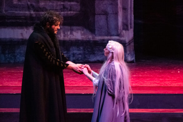 Un uomo e una donna sono in scena sul palco. Entrambi si tengono per mano