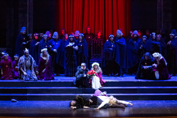Prospettiva centrale del palco. Un uomo e una donna sono distesi sul palco moribondi, dietro di loro altri personaggi li stanno guardando.