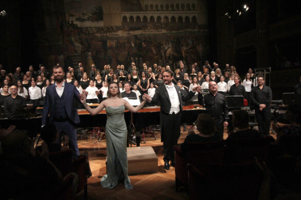 gruppo di cantanti con alle spalle un coro, che procede al ringraziamento del pubblico dopo aver eseguito i "Carmina Burana"