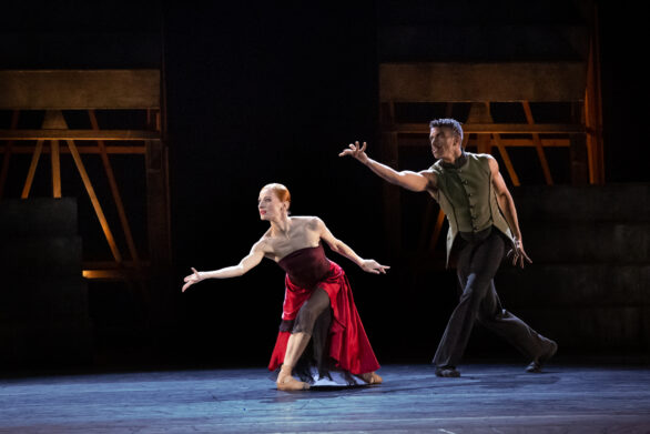 due ballerini in "Carmen". La ballerina ha un abito rosso mentre il ballerino indossa un costume scuro.