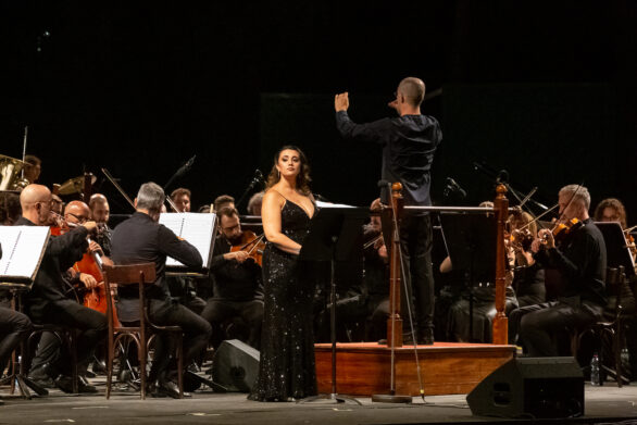 cantante ed orchestra diretti da un direttore durante l'esecuzione di uno spettacolo