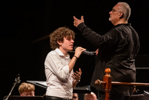 Primo piano di un cantante e del direttore d'orchestra sul palco