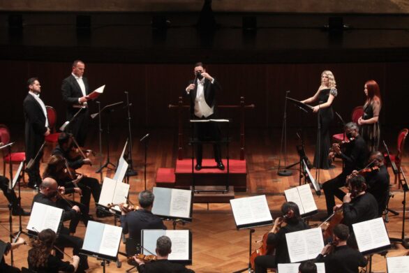 Direttore d’orchestra Michele Spotti al centro, ai lati coristi e violinisti
