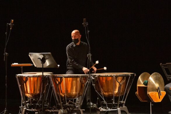 Musicista suona le percussioni al centro della scena