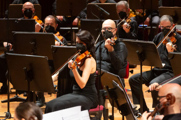 Gruppo di violinisti sul palco del teatro, immersi nella performance